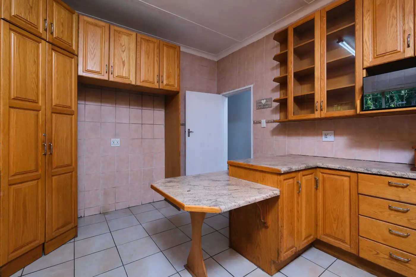 Honey-oak kitchen cabinets with granite breakfast bar