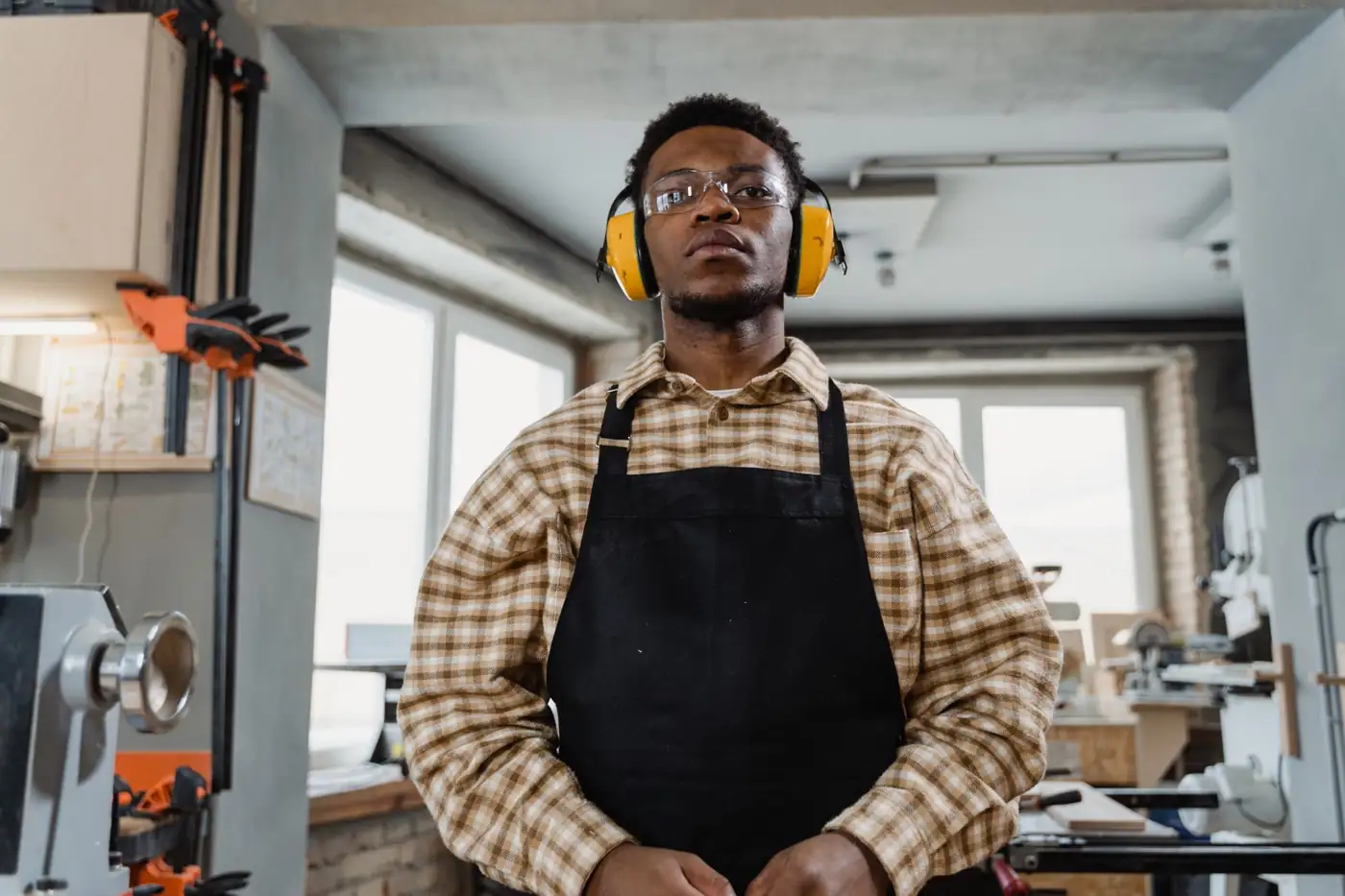 Joiner in ear defenders and apron in the workshop