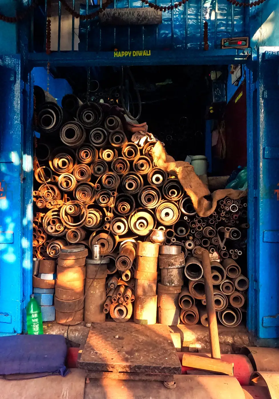 Stacked metal pipes and fittings in a trade shop doorway